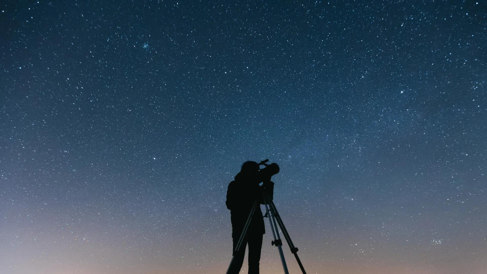 Telescopes set up for stargazing under a starry sky
